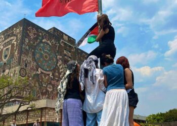 Foto AMEXI /Florentino López. Jóvenes universitarios izan la bandera de Palestina junto a la del Partido Comunista de México Marxista Leninista, en el campamento de CU.