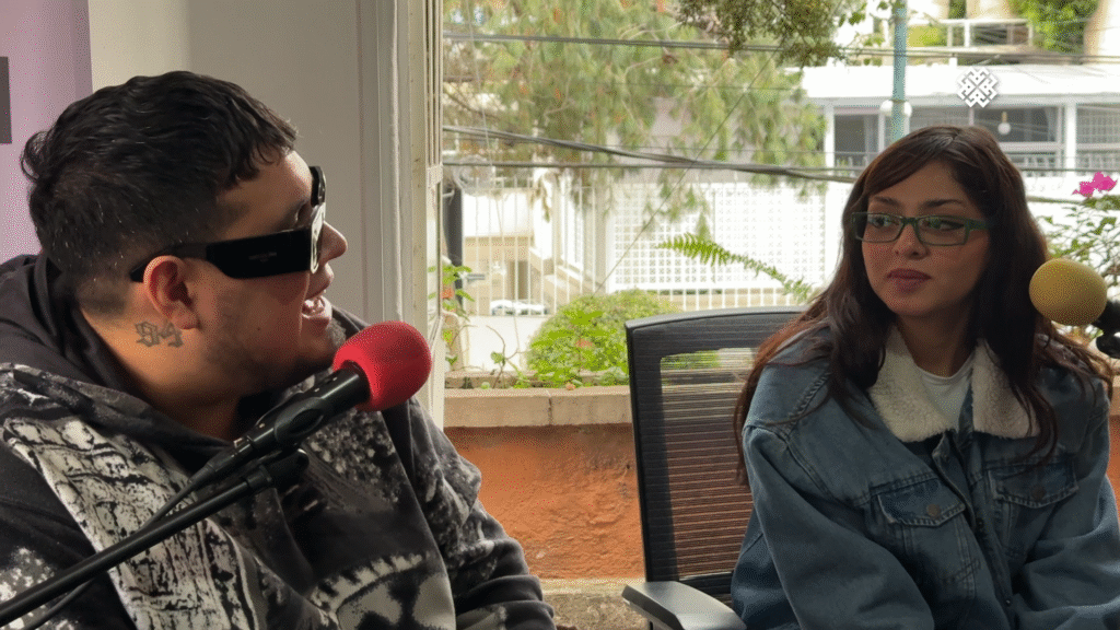 Loojan hablando animadamente en el micrófono rojo mientras Cachirula, del dúo Cachirula & Loojan, escucha atentamente durante su entrevista sobre 'Sexolandia'.