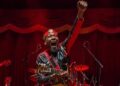 Jimmy Cliff cantando en vivo durante un concierto, mostrando su energía y presencia icónica en el escenario.