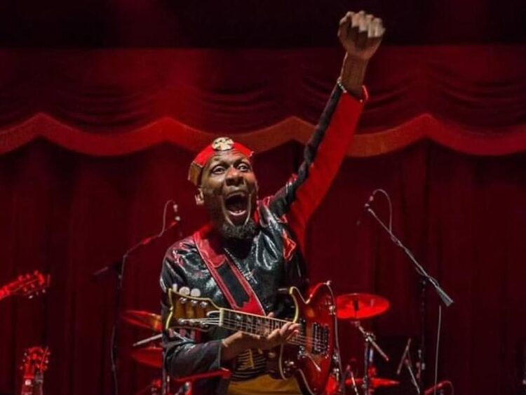 Jimmy Cliff cantando en vivo durante un concierto, mostrando su energía y presencia icónica en el escenario.