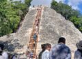 Visitantes subiendo la escalinata de madera del Nohoch Mul en Cobá, disfrutando de vistas de la selva maya.