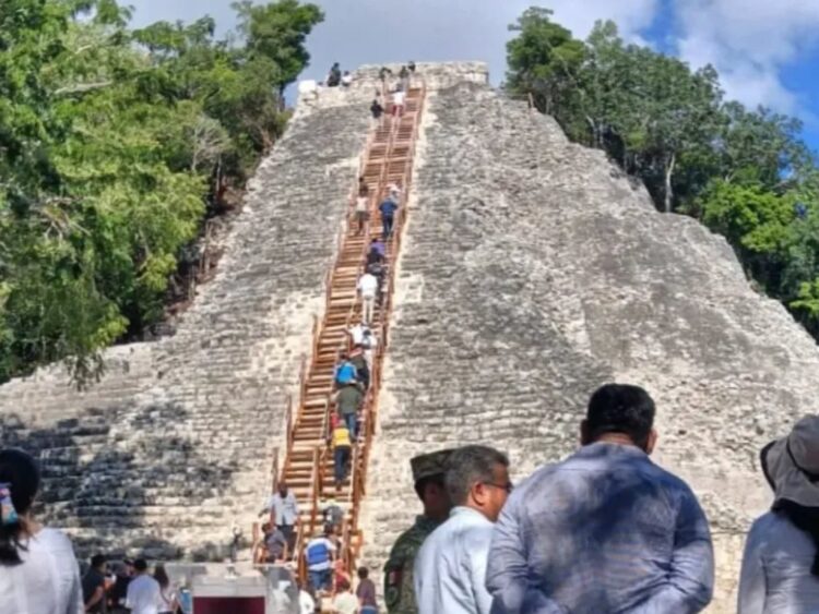 Visitantes subiendo la escalinata de madera del Nohoch Mul en Cobá, disfrutando de vistas de la selva maya.