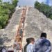 Visitantes subiendo la escalinata de madera del Nohoch Mul en Cobá, disfrutando de vistas de la selva maya.