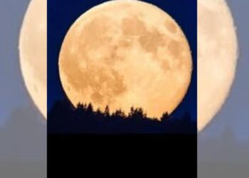 Superluna brillante de diciembre sobre un cielo oscuro, acompañada de trazos luminosos de meteoros Gemínidas.