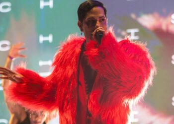 Christian Chávez sonríe durante una entrevista con medios, sosteniendo un micrófono, mientras habla sobre su regreso a México, su documental y la posibilidad de un reencuentro de RBD.