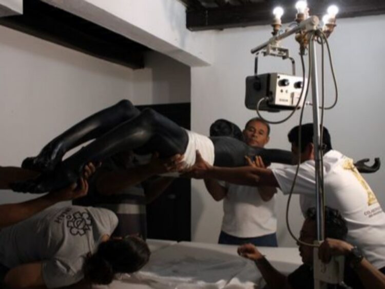 Imagen del Cristo Negro de Campeche durante el inicio de los trabajos de restauración, con especialistas realizando labores de conservación en el templo.