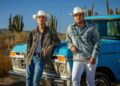 Edgardo Nuñez y Juanpa Salazar avanzan en una pickup azul por el desierto de Hermosillo durante la grabación del video oficial de “Es Por Ti”.