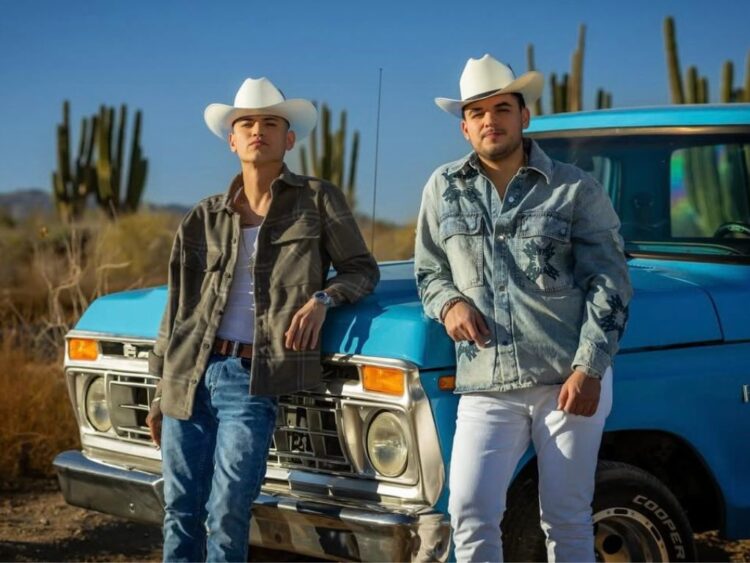 Edgardo Nuñez y Juanpa Salazar avanzan en una pickup azul por el desierto de Hermosillo durante la grabación del video oficial de “Es Por Ti”.