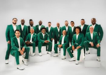 Integrantes de Grupo Niche en el escenario durante un concierto, celebrando su incorporación a Cardenas Marketing Network y su proyección internacional.