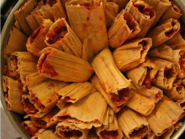 Participantes aprenden a preparar tamales en una cocina profesional durante el taller práctico impartido por la chef Carolina Medina.