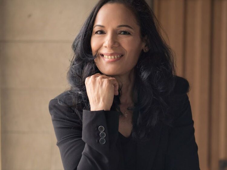 Persona sentada frente a una computadora en oficina, con gesto de cansancio y estrés, simbolizando el impacto del burnout en el trabajo y la intención de renuncia.