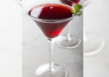 Mocktail servido en copa elegante con hielo, hierbas frescas y cítricos, como ejemplo de bebidas sin alcohol con intención y balance.