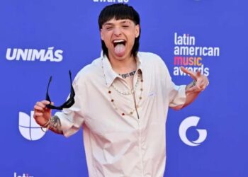 Peso Pluma en escenario durante anuncio de su gira Dinastía 2026 por Estados Unidos, con luces y público al fondo.