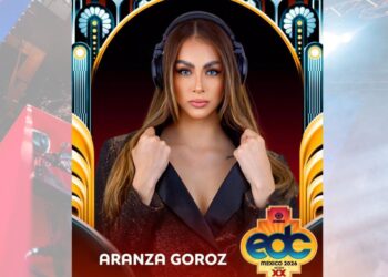 DJ mexicana tocando en un escenario masivo de música electrónica ante una multitud durante un festival nocturno.