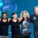 Integrantes de Metallica interpretan “Enter Sandman” en un concierto masivo, con luces intensas y miles de fans frente al escenario.