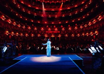 Nicki Nicole canta en el escenario del Teatro Colón acompañada por una orquesta sinfónica, durante un concierto que fusiona música urbana y arreglos clásicos.