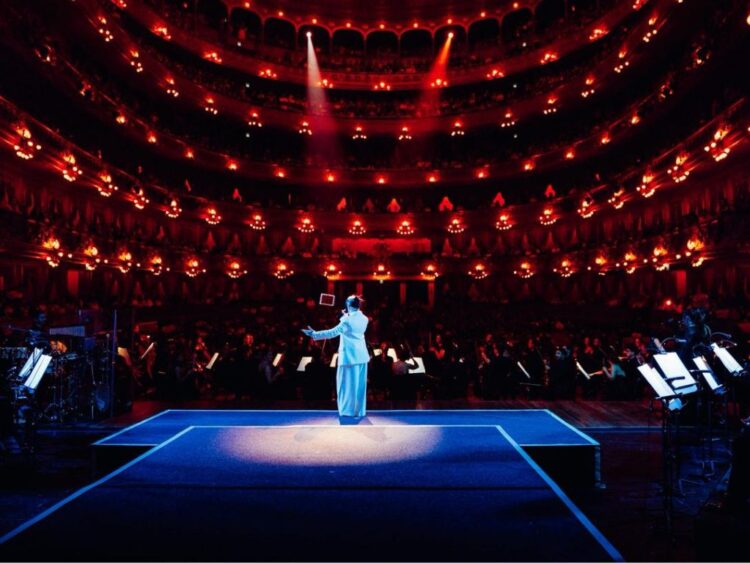 Nicki Nicole canta en el escenario del Teatro Colón acompañada por una orquesta sinfónica, durante un concierto que fusiona música urbana y arreglos clásicos.