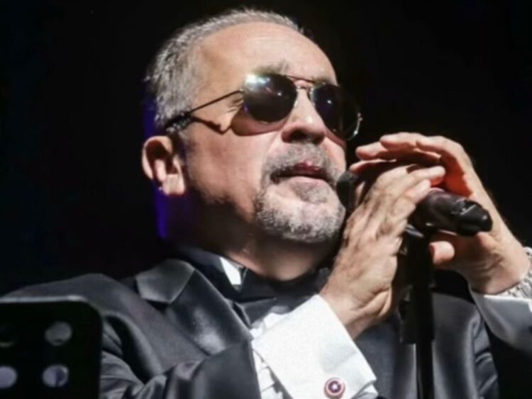 Músico de salsa en presentación pública, rodeado de atención mediática ante reportes sobre su estado de salud.