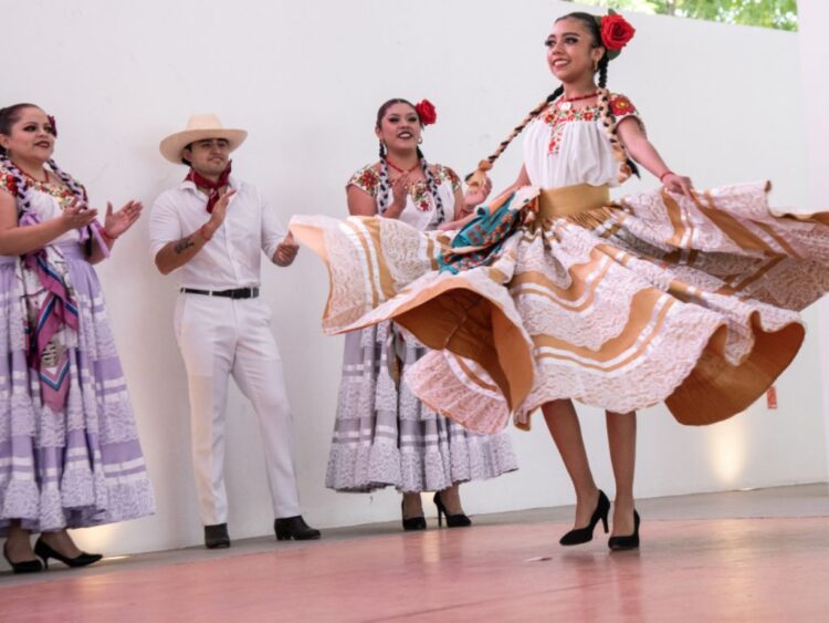 Jóvenes con atuendos tradicionales y tocados florales desfilan en el Centro Cultural Universitario de la UAM Xochimilco durante la Fiesta de la Flor Más Bella del Ejido.