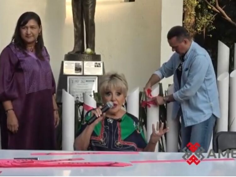 Escenario con fotografías, flores y público reunido durante un homenaje musical dedicado a un icónico cantante mexicano.