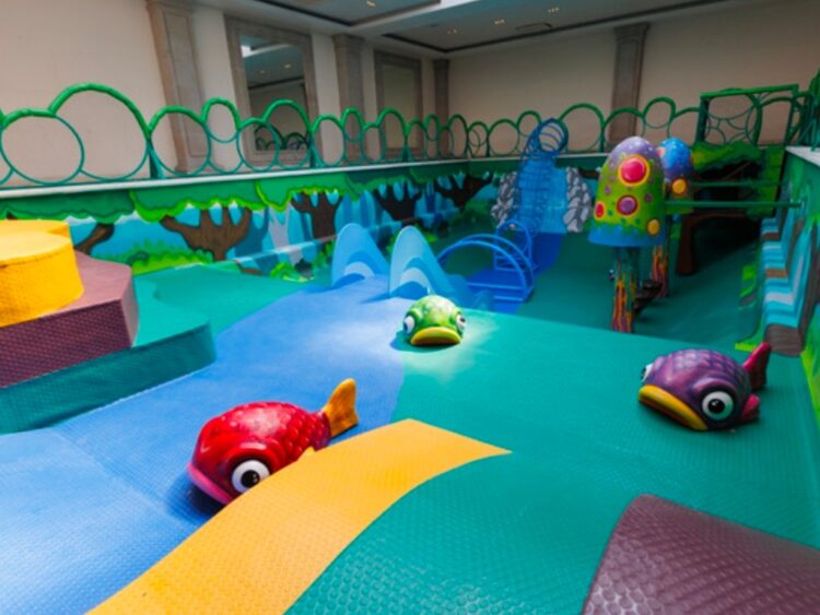 Niñas y niños juegan en la Alberca Encantada, un espacio lúdico con estructuras que simulan un bosque fantástico en el Complejo Cultural Los Pinos.