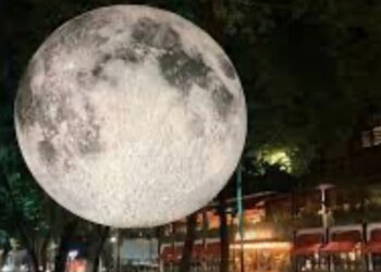 Instalación de una luna gigante iluminada durante el Festival Internacional de las Luces México, rodeada de visitantes en calles de la Ciudad de México.