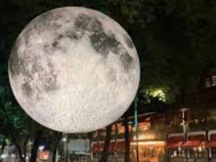 Instalación de una luna gigante iluminada durante el Festival Internacional de las Luces México, rodeada de visitantes en calles de la Ciudad de México.