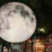 Instalación de una luna gigante iluminada durante el Festival Internacional de las Luces México, rodeada de visitantes en calles de la Ciudad de México.