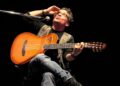 Alejandro Filio durante una presentación en vivo interpretando sus canciones de trova con guitarra acústica.