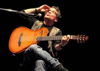 Alejandro Filio durante una presentación en vivo interpretando sus canciones de trova con guitarra acústica.