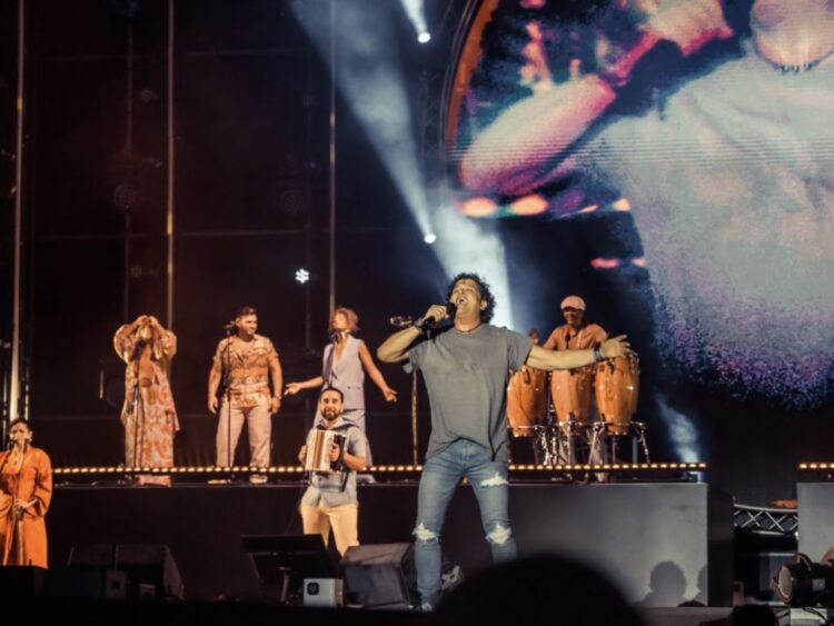 Carlos Vives canta en el escenario del Vibra Latina Festival en Aruba frente a una multitud entusiasta.