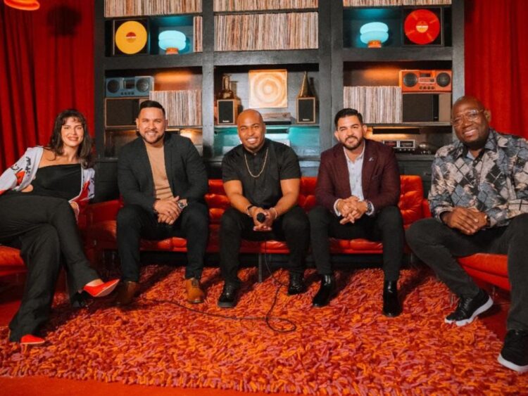 Nathy Peluso canta junto a la orquesta de Grupo Niche en un escenario durante un concierto de salsa en vivo.