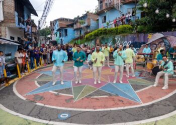 Integrantes de Grupo Niche interpretan “Realidad-Es” en un ambiente urbano inspirado en el barrio Siloé de Cali, reflejando la esencia popular de la salsa.