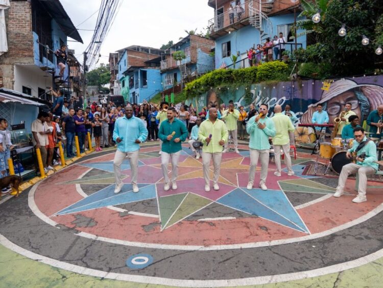 Integrantes de Grupo Niche interpretan “Realidad-Es” en un ambiente urbano inspirado en el barrio Siloé de Cali, reflejando la esencia popular de la salsa.