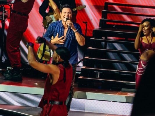 Chayanne durante su concierto en el Auditorio Nacional, vestido de negro, mientras interpreta sus éxitos ante un público eufórico.