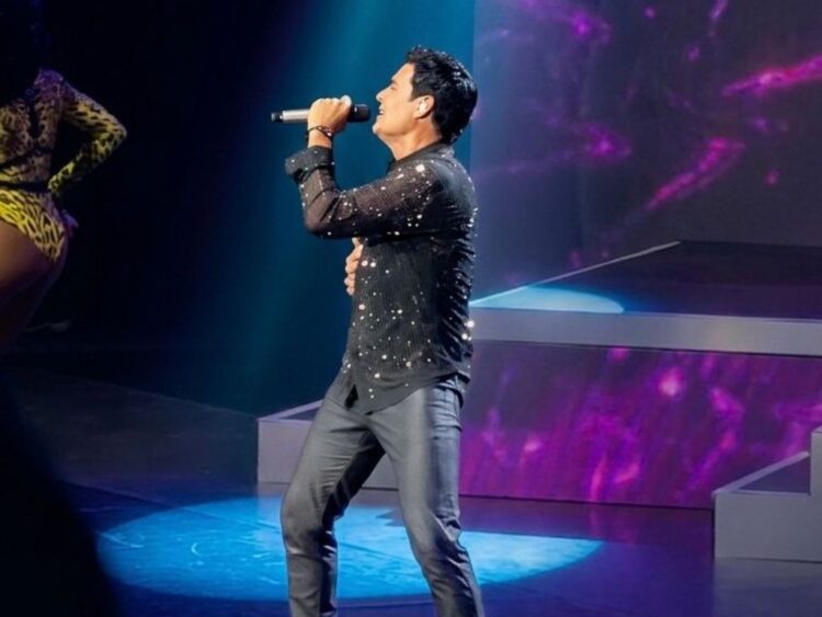 Chayanne durante su concierto en el Auditorio Nacional, vestido de negro, mientras interpreta sus éxitos ante un público eufórico.