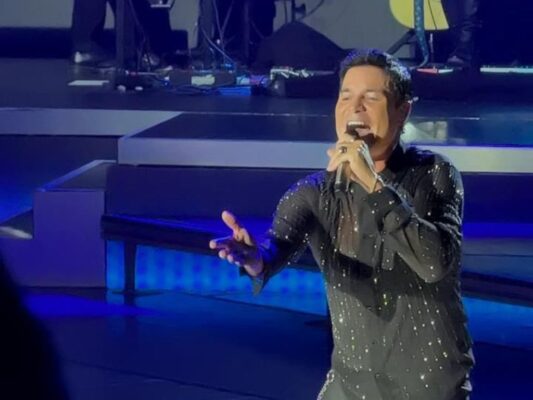 Chayanne durante su concierto en el Auditorio Nacional, vestido de negro, mientras interpreta sus éxitos ante un público eufórico.