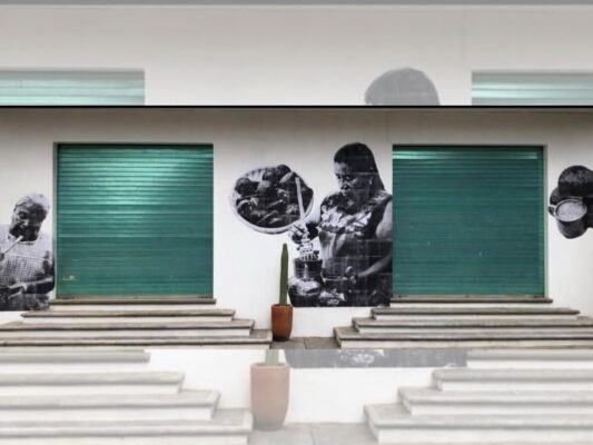 Murales y fotomurales comunitarios en San Bartolo Coyotepec que retratan artesanos del barro negro y tradiciones locales en espacios públicos.