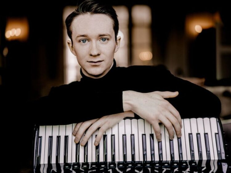 Escenario del Teatro Mayor de Bogotá con músicos interpretando violonchelo, acordeón, piano y guitarra en una serie de conciertos internacionales.