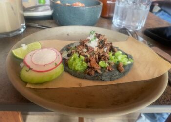 El chef Erik García prepara tacos con ingredientes innovadores en una cocina donde fusiona tradición mexicana y técnicas contemporáneas.