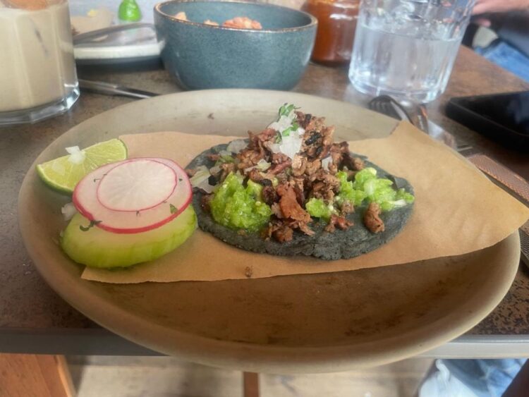 El chef Erik García prepara tacos con ingredientes innovadores en una cocina donde fusiona tradición mexicana y técnicas contemporáneas.