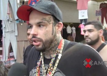 Emiliano Aguilar camina por calles de Tepito durante la grabación de su videoclip “Harley Quinn”, rodeado de un entorno urbano.
