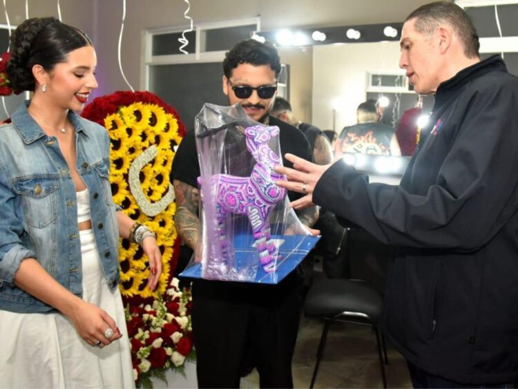 Christian Nodal y Ángela Aguilar reciben una escultura de El Venado en arte huichol de manos del alcalde Luis Mendoza previo a la presentación del cantante en la Plaza de Toros México.