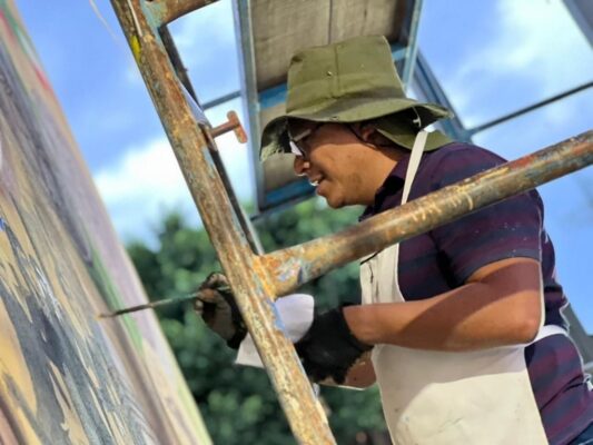 Artistas mexicanos trabajan en un mural monumental sobre la historia del futbol en avenida Centenario, en Gustavo A. Madero, Ciudad de México.