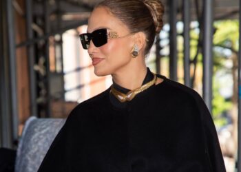 Jennifer Lopez posa en la alfombra roja de la premiere de Office Romance con un vestido strapless color nude de transparencias, escote en V y aplicaciones brillantes, acompañada por Brett Goldstein.