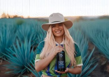 Botella de 200 Copas by Casa Dragones junto a elementos promocionales de Karol G, como parte de la alianza que llevará el tequila oficial a los conciertos de la gira mundial Tropitour.
