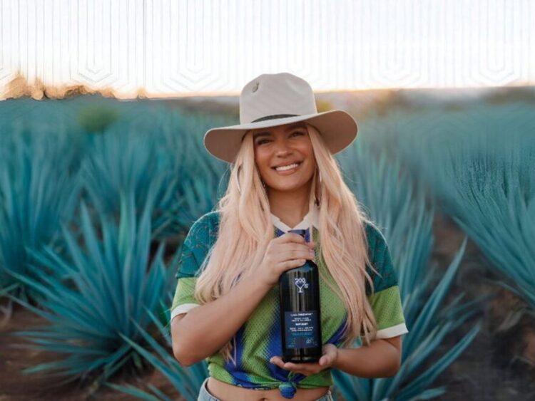 Botella de 200 Copas by Casa Dragones junto a elementos promocionales de Karol G, como parte de la alianza que llevará el tequila oficial a los conciertos de la gira mundial Tropitour.