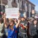 Universitaria chilena muestra un cartel contra la disminución del presupuesto para educación.
