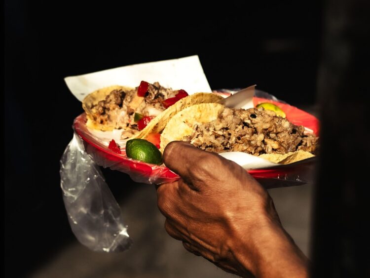 Plato de tacos mexicanos tradicionales servido con salsas y guarniciones típicas.