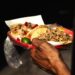 Plato de tacos mexicanos tradicionales servido con salsas y guarniciones típicas.